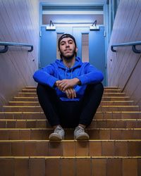 Portrait of young man sitting on staircase