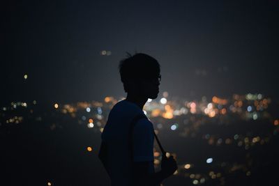 Rear view of woman standing at night