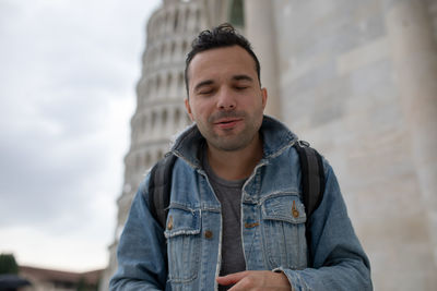 Man smiling with closed eyes outdoors