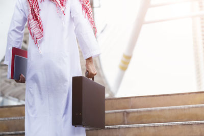 Midsection of businessman wearing traditional clothing while standing on steps