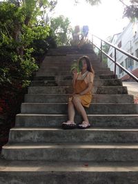 Low angle view of woman sitting on staircase