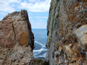 Scenic view of rocky beach against sky