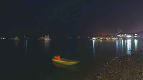 Boats moored in sea against sky at night