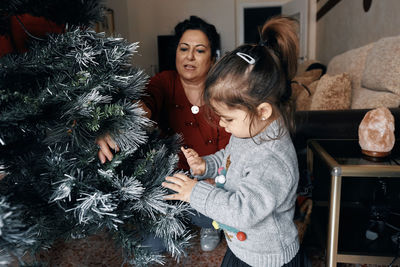 Portrait of happy girl with christmas tree at home