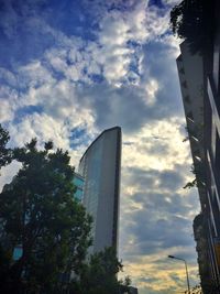 Low angle view of modern building against cloudy sky