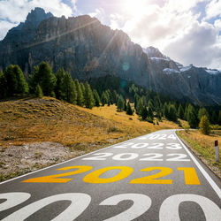 Road leading towards mountains against sky