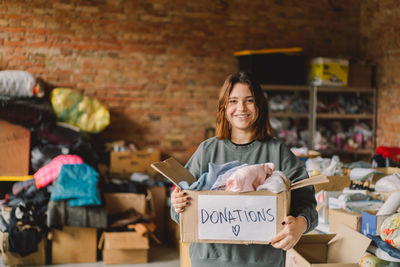 Volunteer teengirl preparing donation boxes for people.