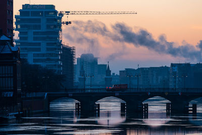 Bridge over river against sky during sunset