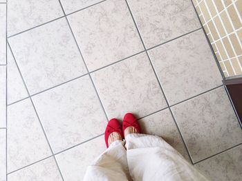 Low section of woman standing on tiled floor