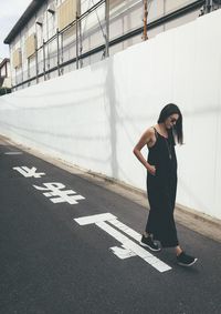 Full length of mid adult woman walking on road