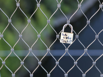 Close-up of padlocks on chainlink fence