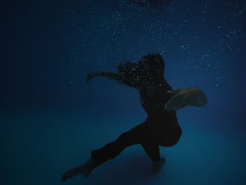 Young woman swimming underwater in pool