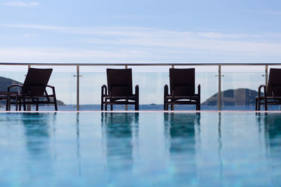 Swimming pool by sea against sky