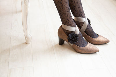 Low section of woman standing on hardwood floor