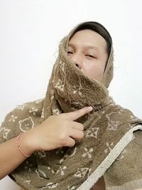 Portrait of woman holding ice cream against wall