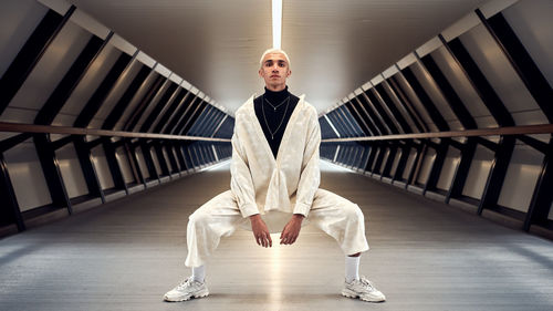 Portrait of young man standing against wall