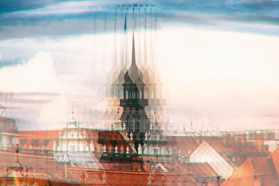 Digital composite image of cityscape against sky seen through glass window