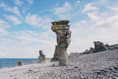 Scenic view of rocks on beach against sky