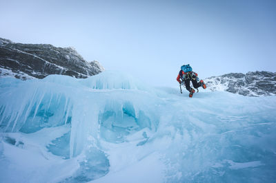 People on snowcapped mountain against sky