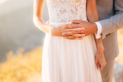 Midsection of couple holding hands