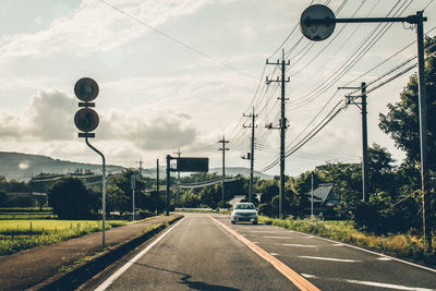 Road by street light against sky
