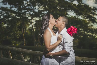 Young couple kissing against trees