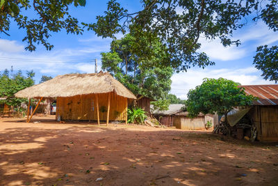 House amidst trees and houses against sky