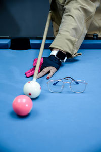 Low section of person playing pool