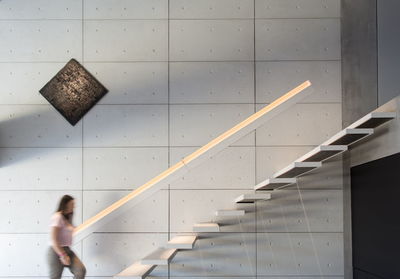 Woman walking on staircase of building