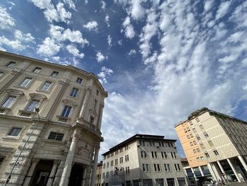 Low angle view of buildings against cloudy sky