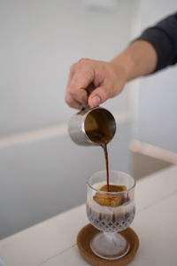 Cropped hand of person pouring water