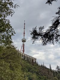 Low angle view of communications tower and buildings against sky