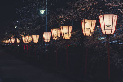 Illuminated lanterns hanging on street in city at night