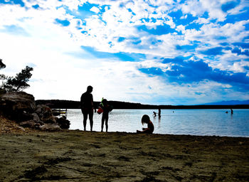 People on beach against sky