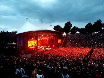 Crowd at illuminated park against sky at night