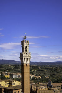 Aerial view of siena from facciatone - torre del mangia and red tiled traditional rooftops