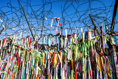 Low angle view of decorations hanging against clear blue sky