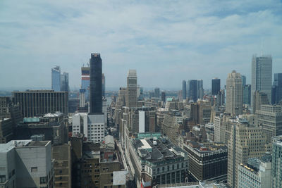 Aerial view of buildings in city against sky