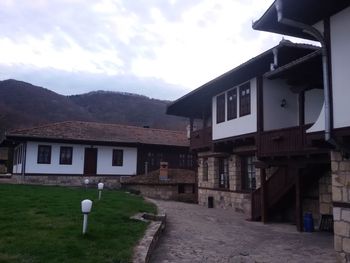 Houses by mountain against sky