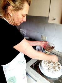 Midsection of woman having food at home