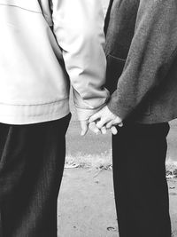 Midsection of couple holding hands