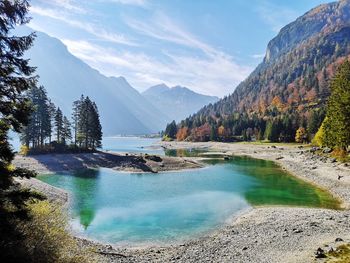 Scenic view of lake by mountains against sky