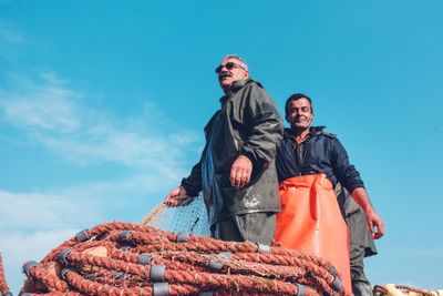 Low angle view of man with arms raised against sky