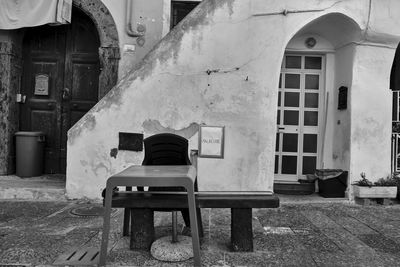 Man sitting on bench against building