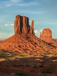 Rock formations on landscape against cloudy sky