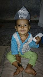 Portrait of cute boy sitting outdoors