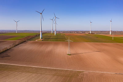 Aerial view of a rural area with a wind farm and electricity pylons for the energy transition