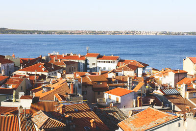 Red roofs of old town piran with main church against the sunrise sky, adriatic sea. slovenia