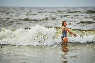 Rear view of woman surfing in sea