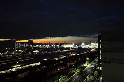 High angle view of illuminated city street against sky at night